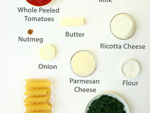 Ingredients labeled -- whole peeled tomatoes, milk, nutmeg, butter, ricotta cheese, onion, parmesan cheese, flour, manicotti, and spinach