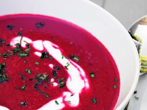 Close-up of the beet soup showing the sour cream swirl and parsley garnish